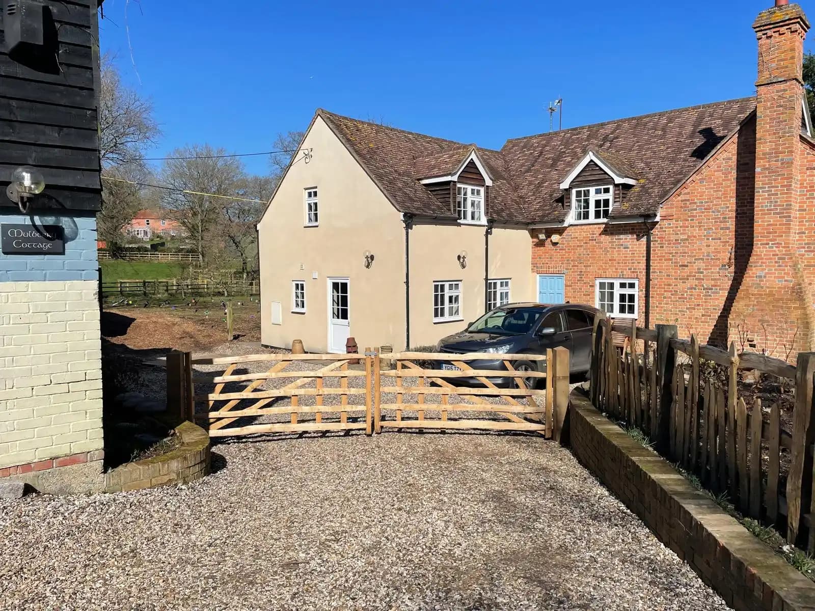 Timber five bar driveway gate in front of a country house