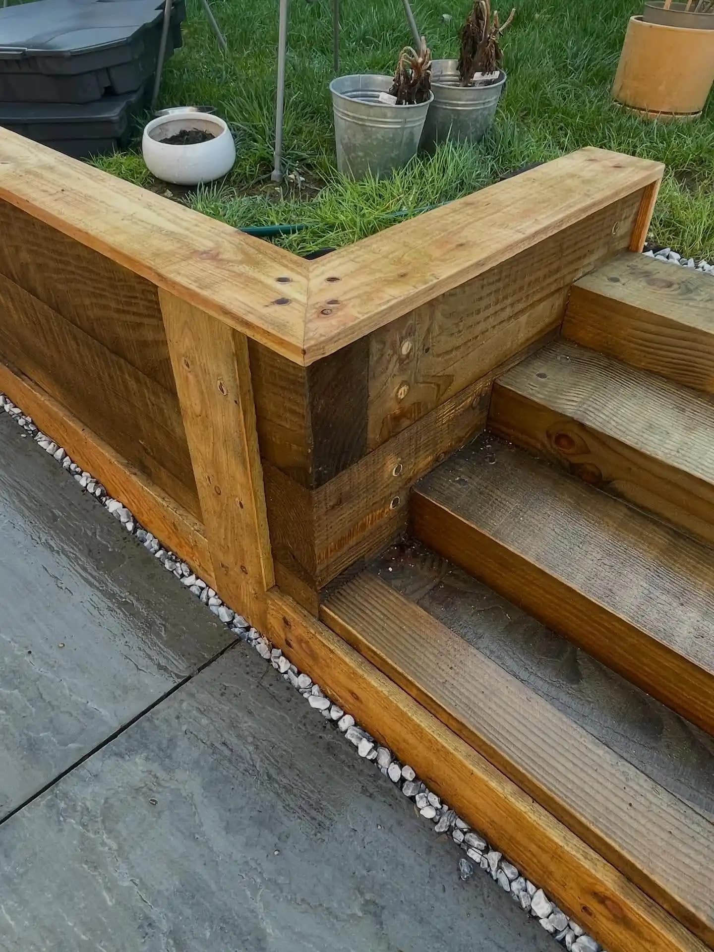 Timber sleeper wall and garden steps beside a paved patio.