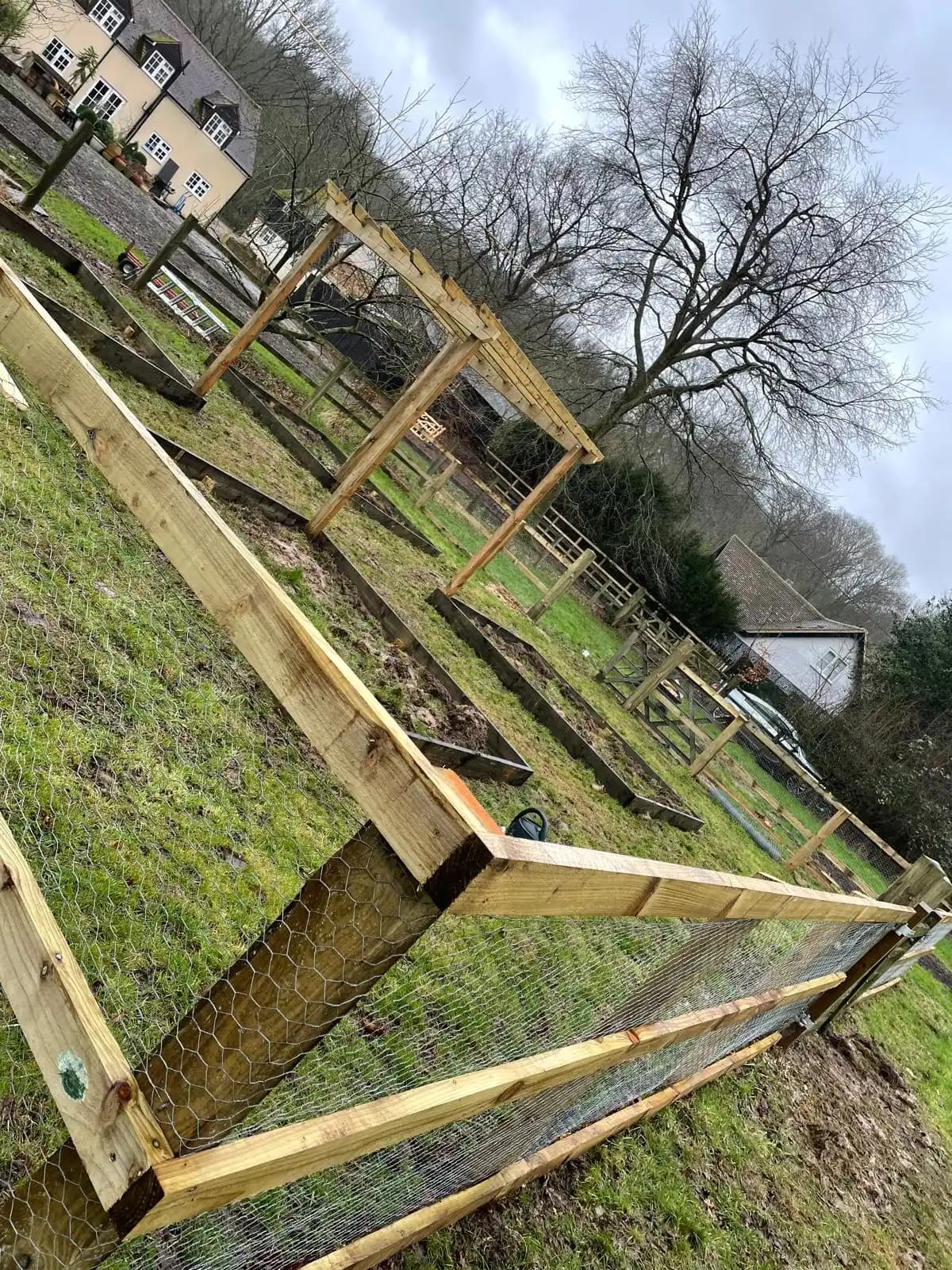 Angled view of a post and rail fence around a paddock