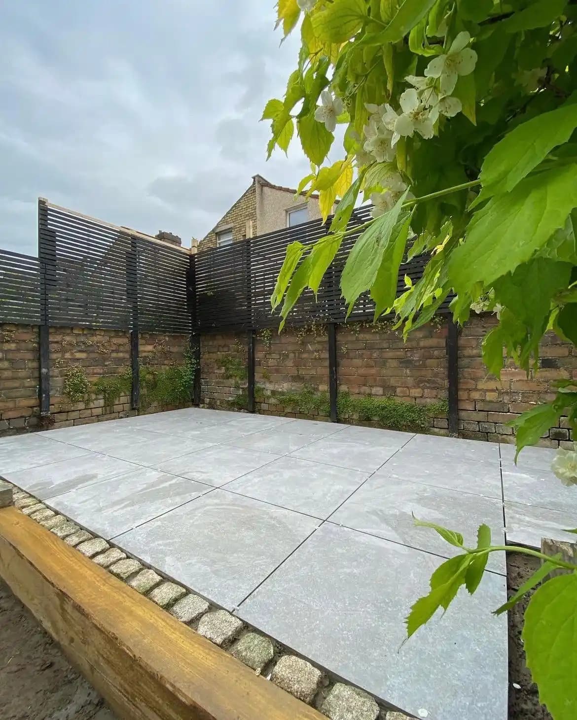 Black slatted screening around a new paved patio