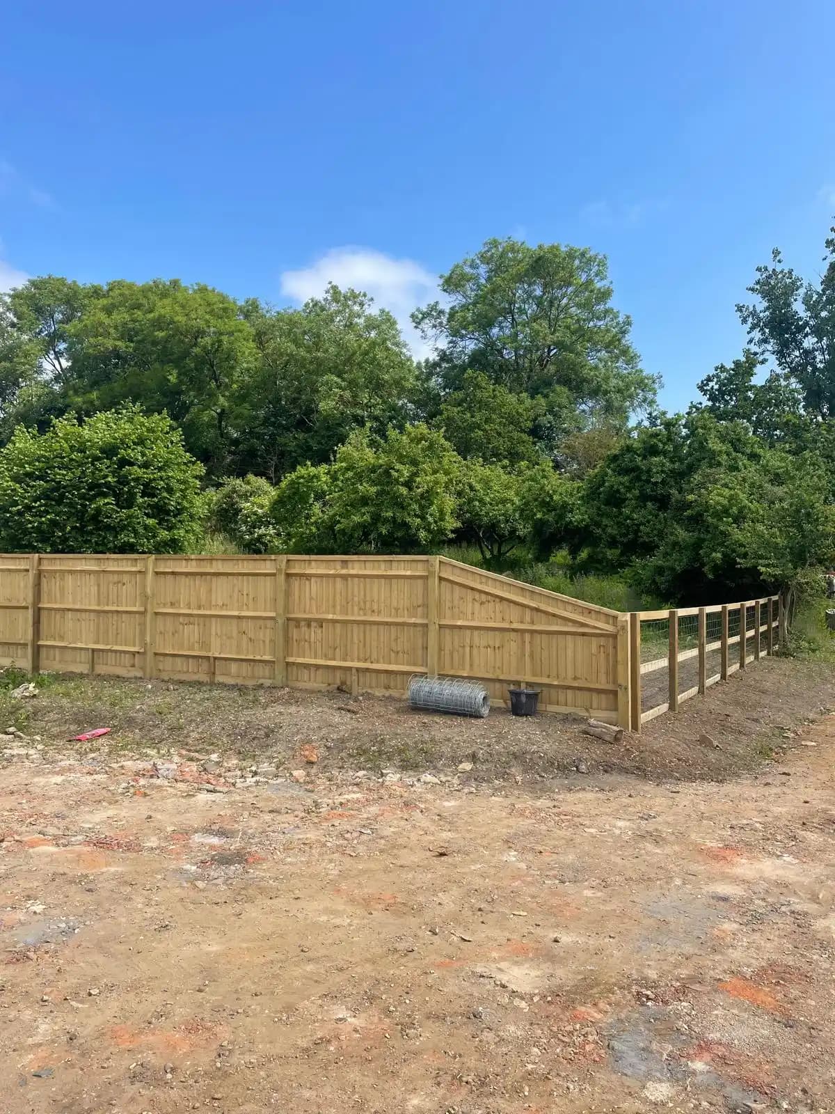 Closeboard fence around a landscaped garden under blue sky