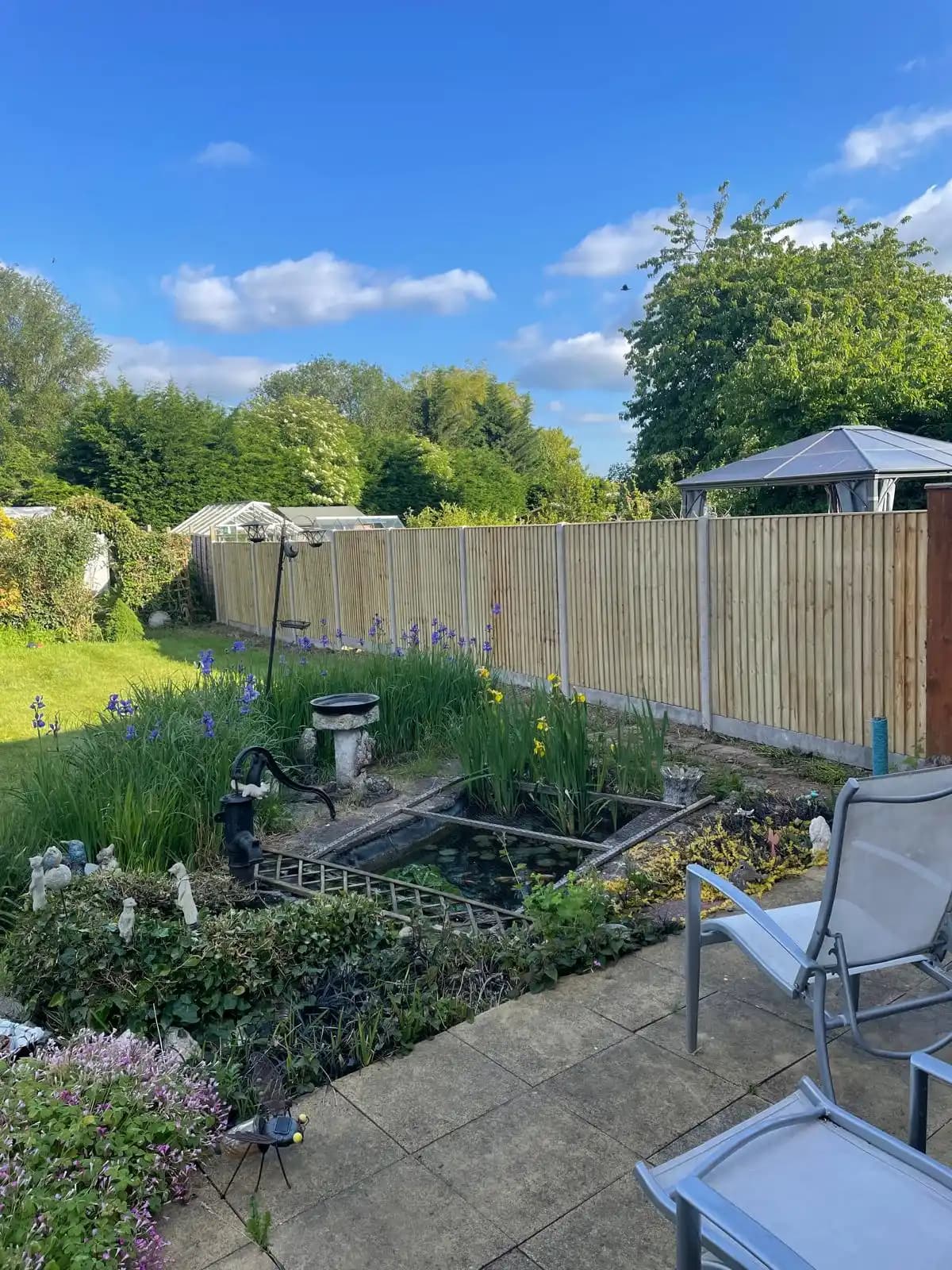Closeboard fence around a landscaped garden pond