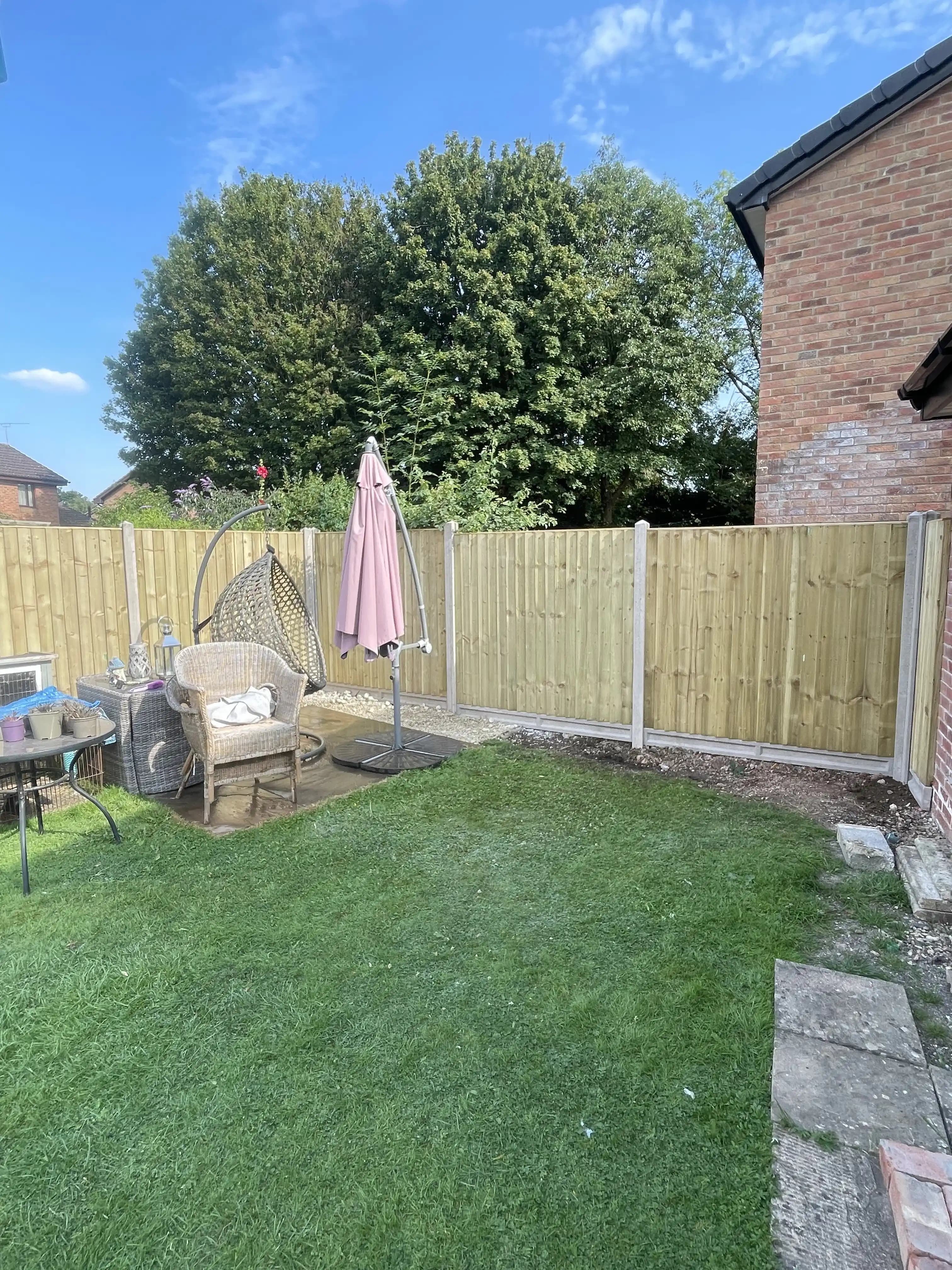 Closeboard fence around a patio and lawn garden