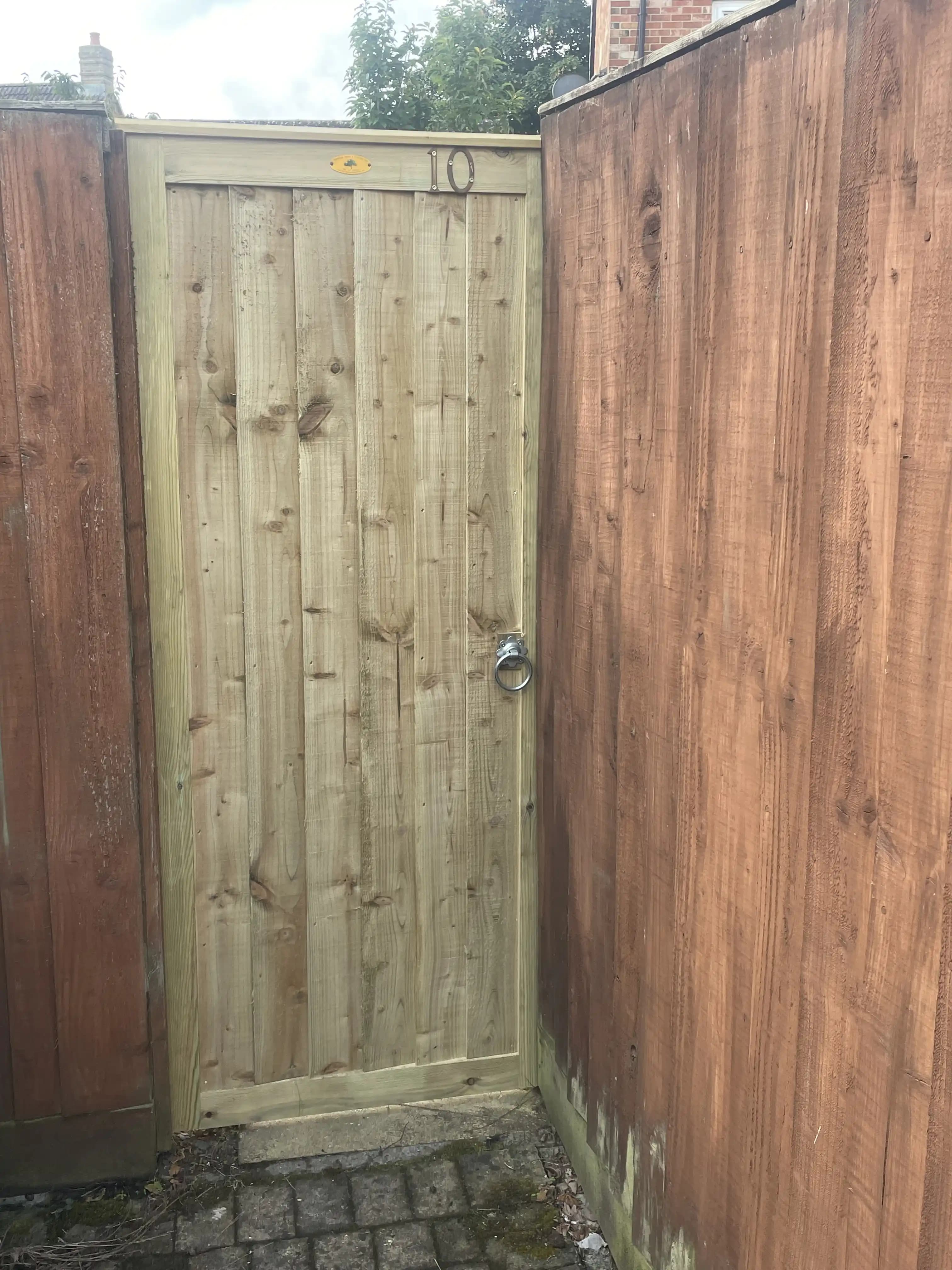 Timber garden gate fitted in a fence corner
