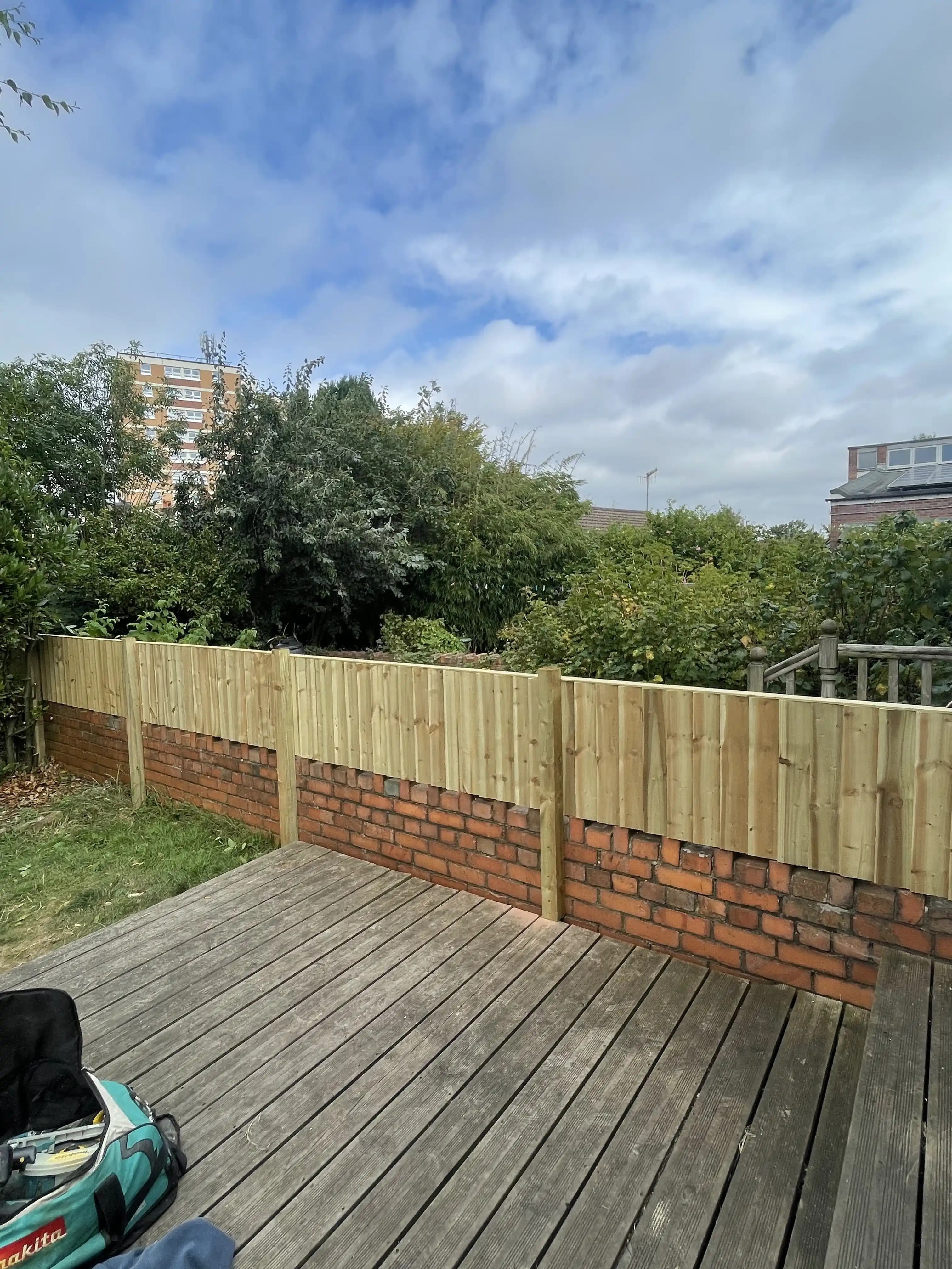 Closeboard fence along a decking boundary with garden view