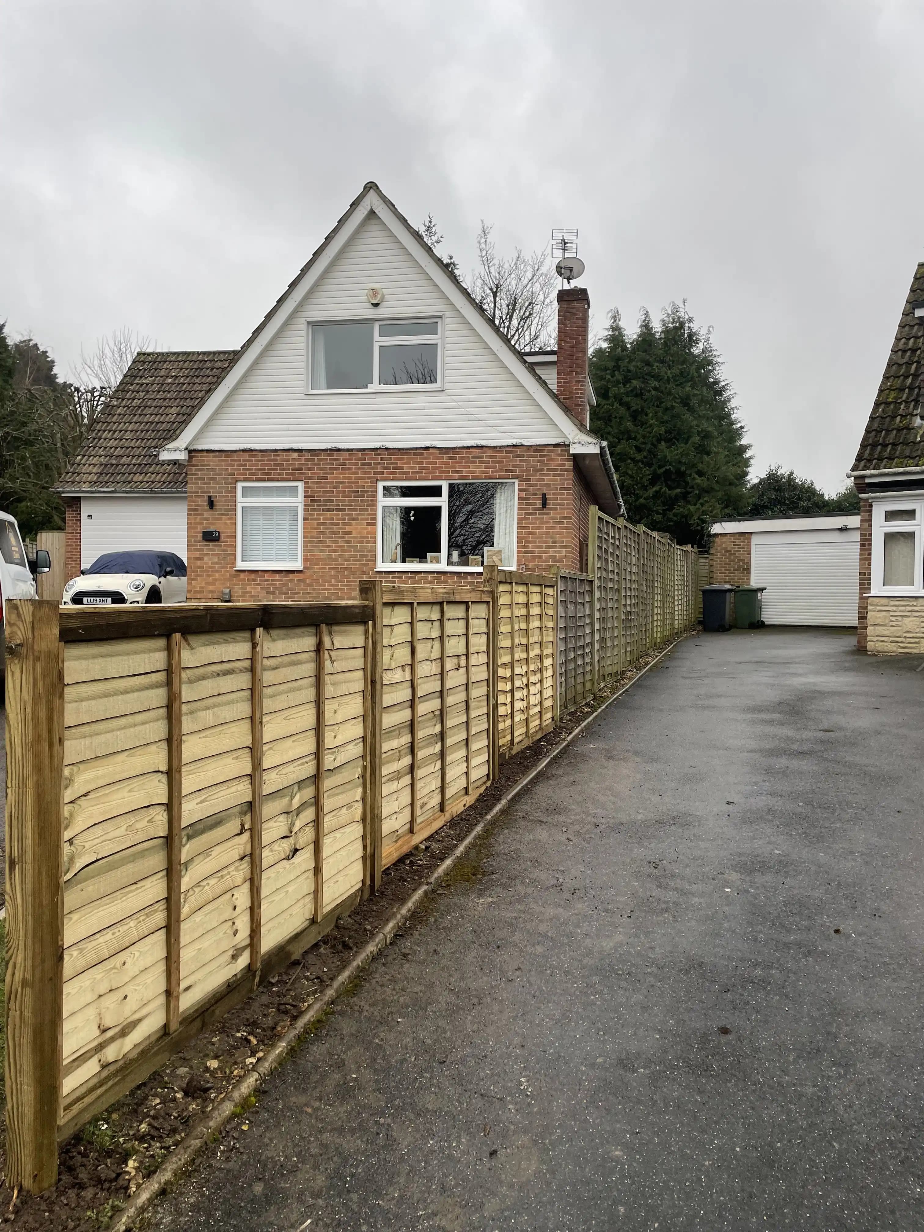 Closeboard boundary fencing along a driveway on an overcast day