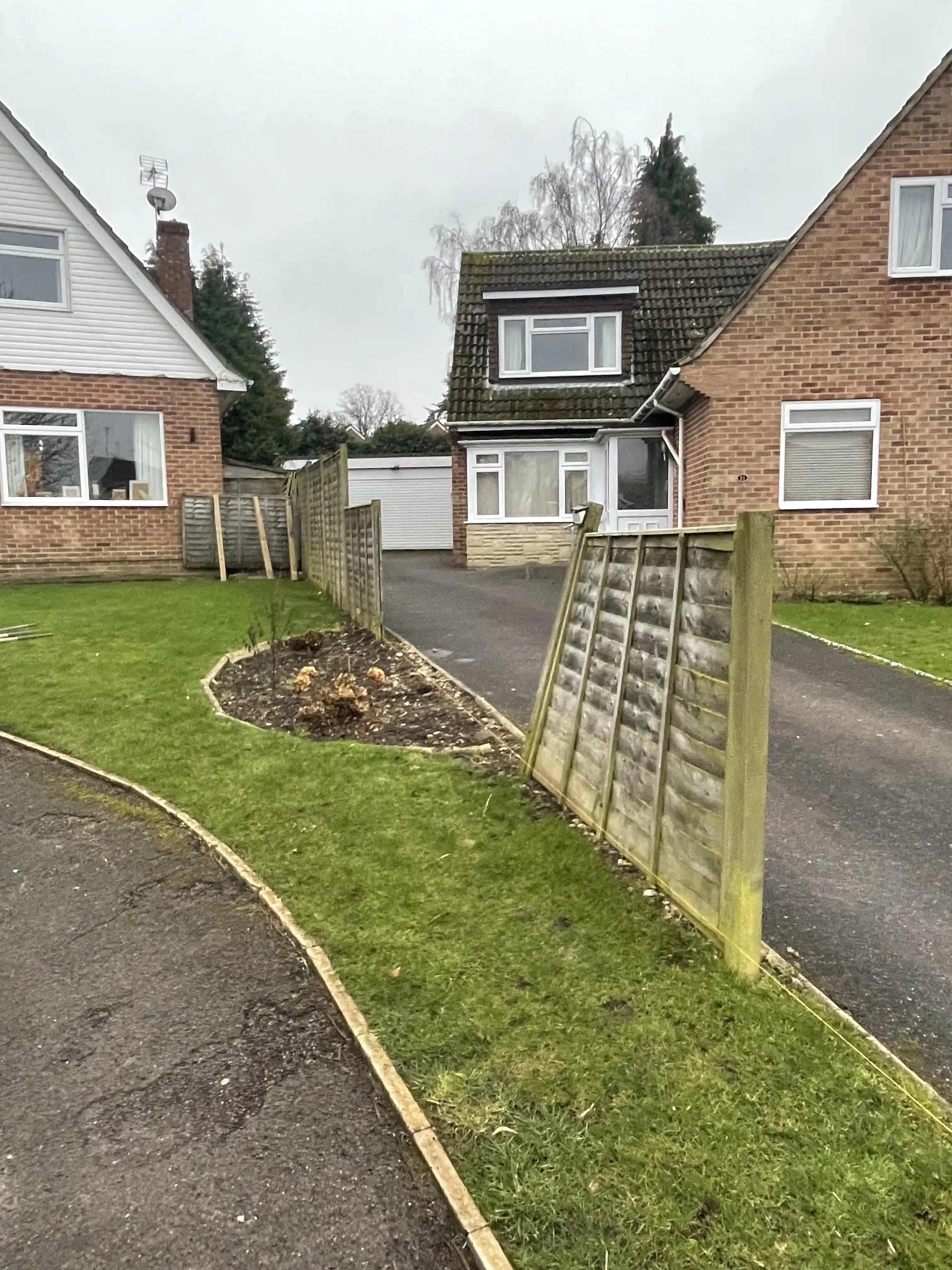 New closeboard fence running along a front garden driveway