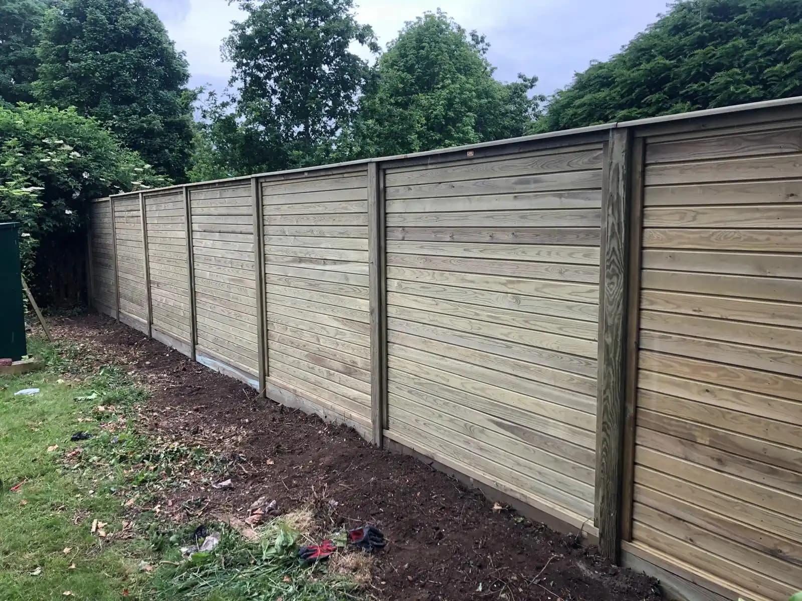 Horizontal lap panel boundary fence along a garden edge