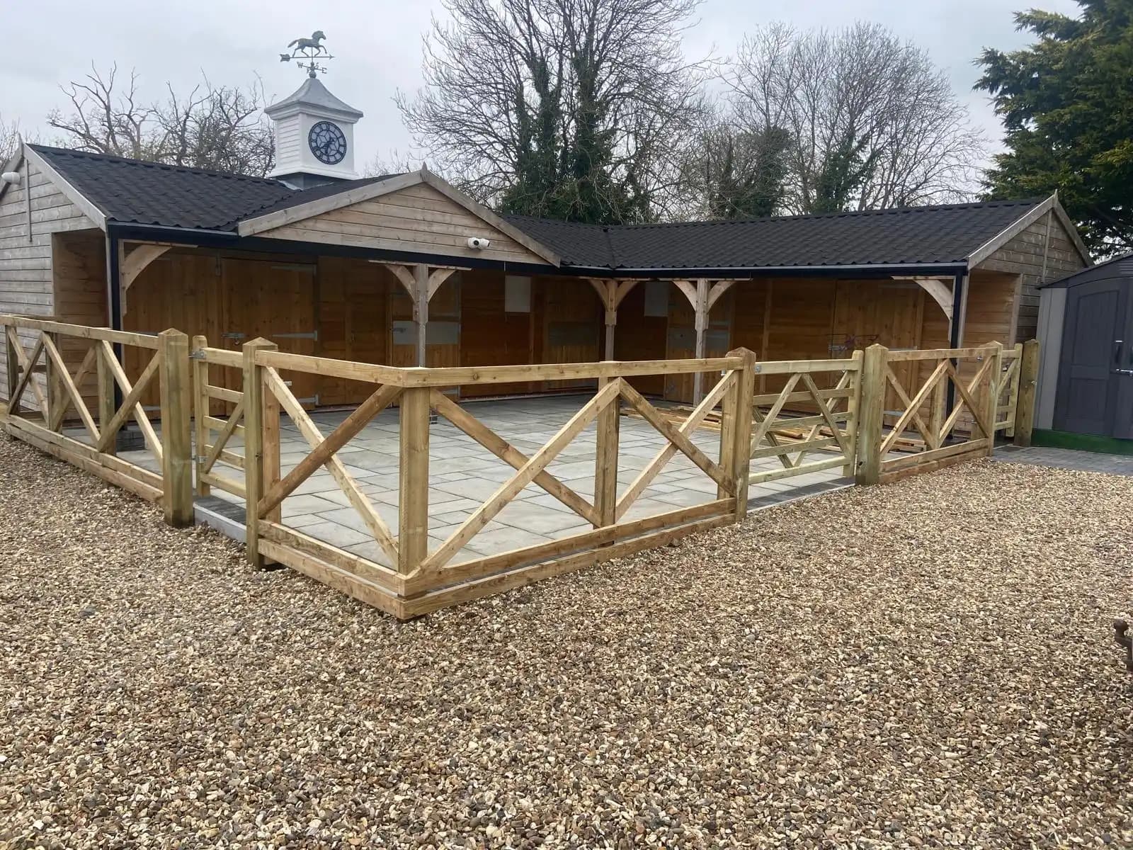 Rustic timber gazebo with matching railings on a gravel area