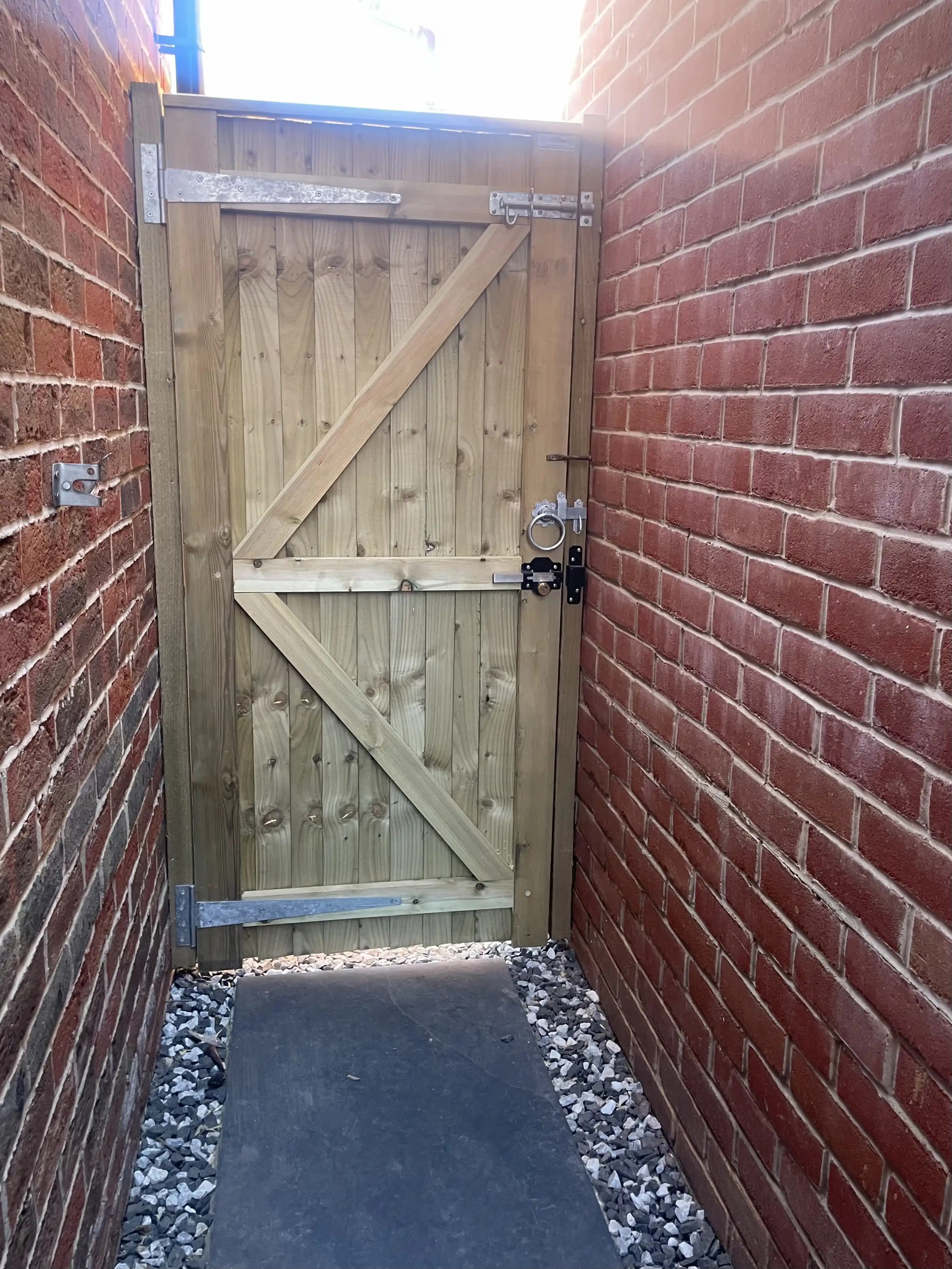 Ledged timber garden gate at the end of a side passage