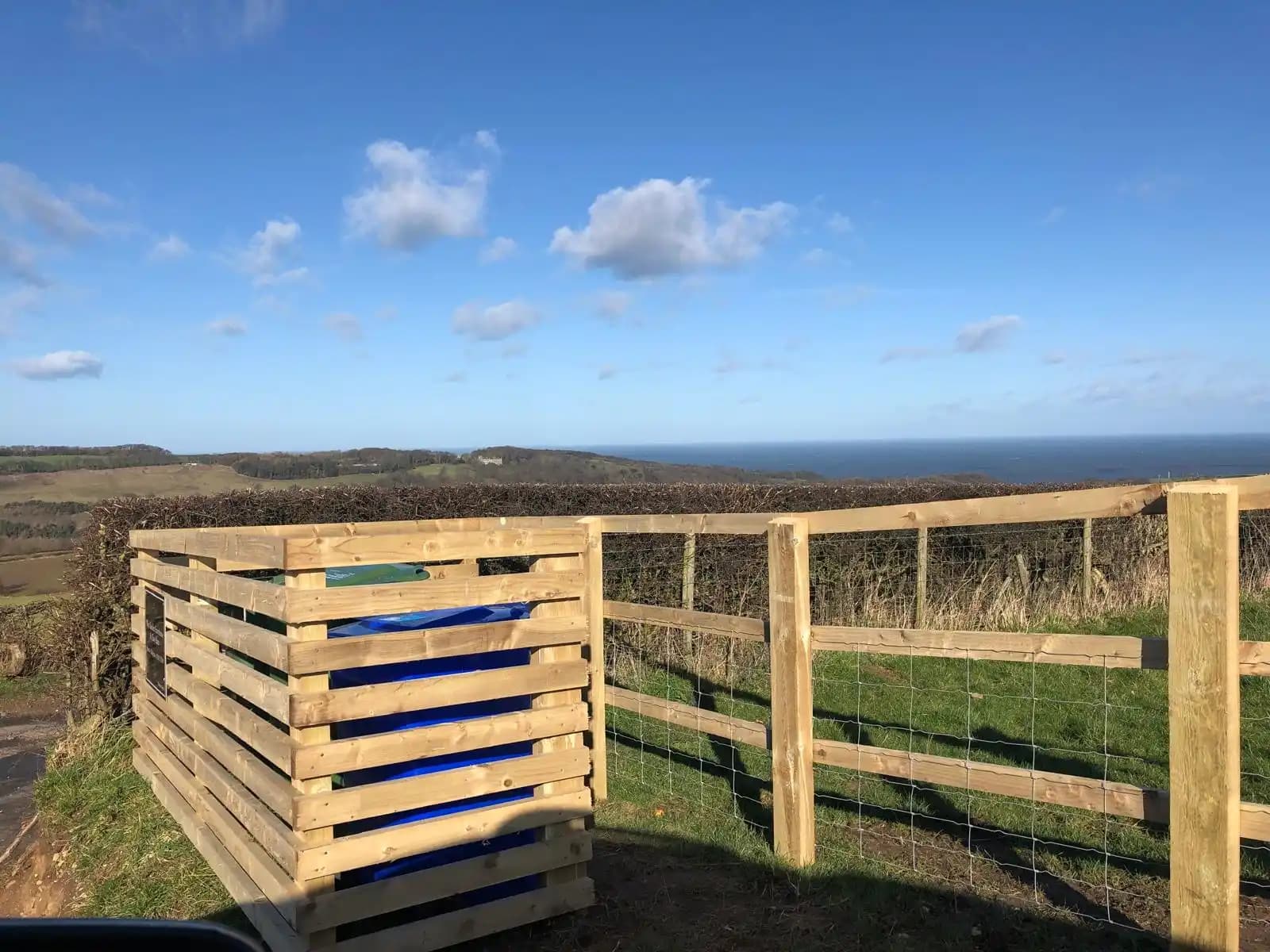 Timber field gate and post and rail fence overlooking countryside