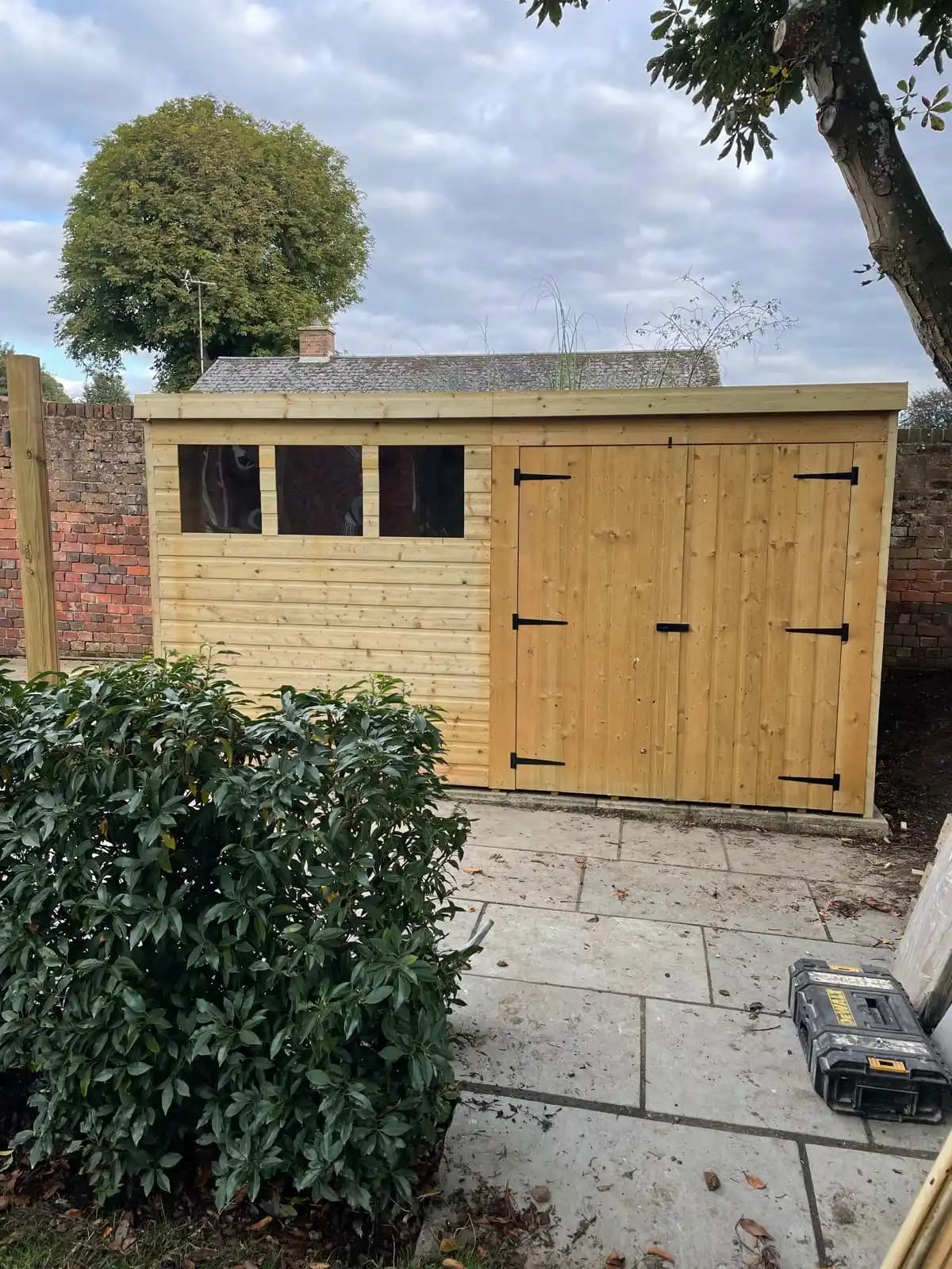 Timber garden room with double doors beside a patio