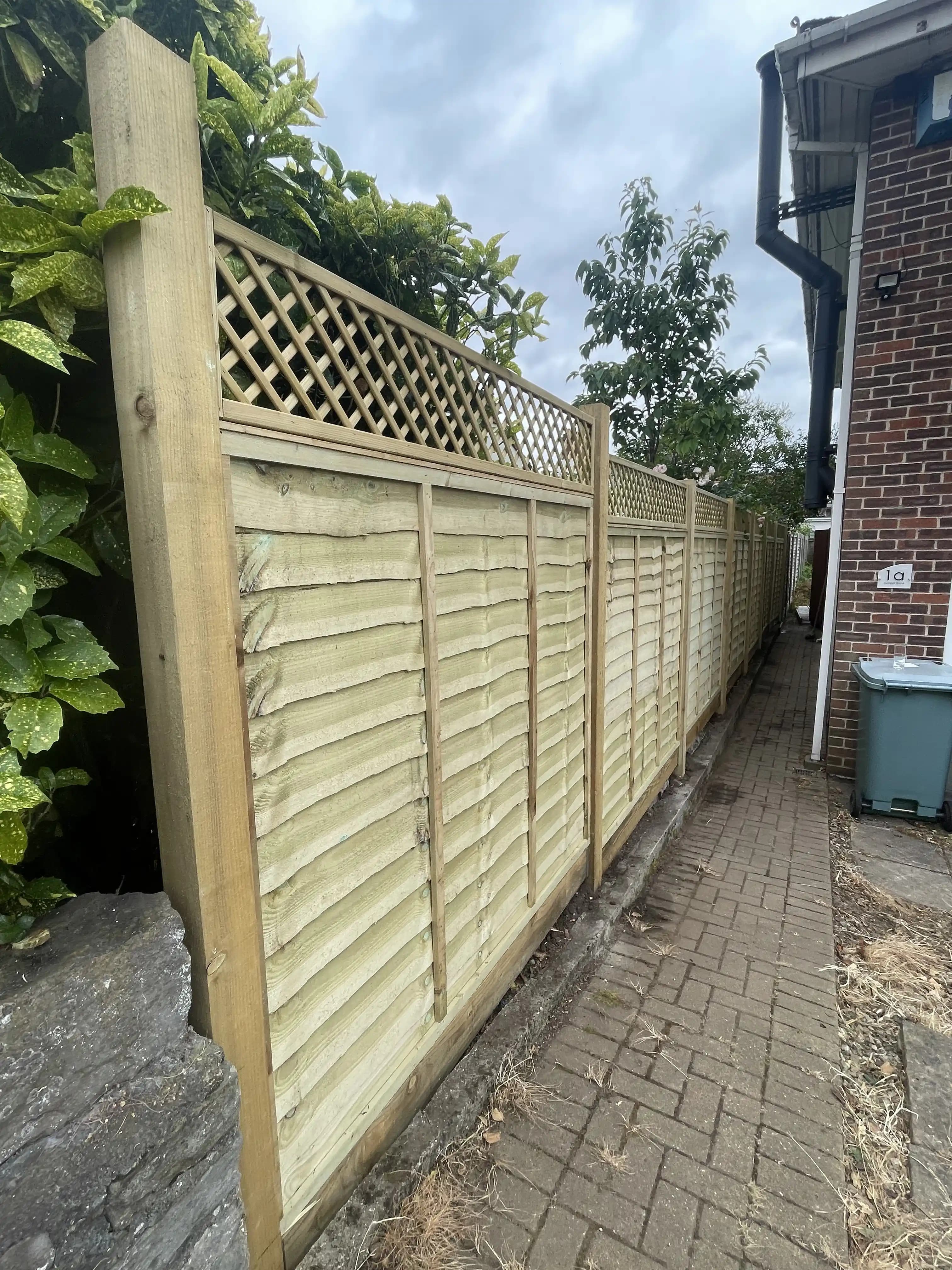 Trellis top boundary fence along a side path