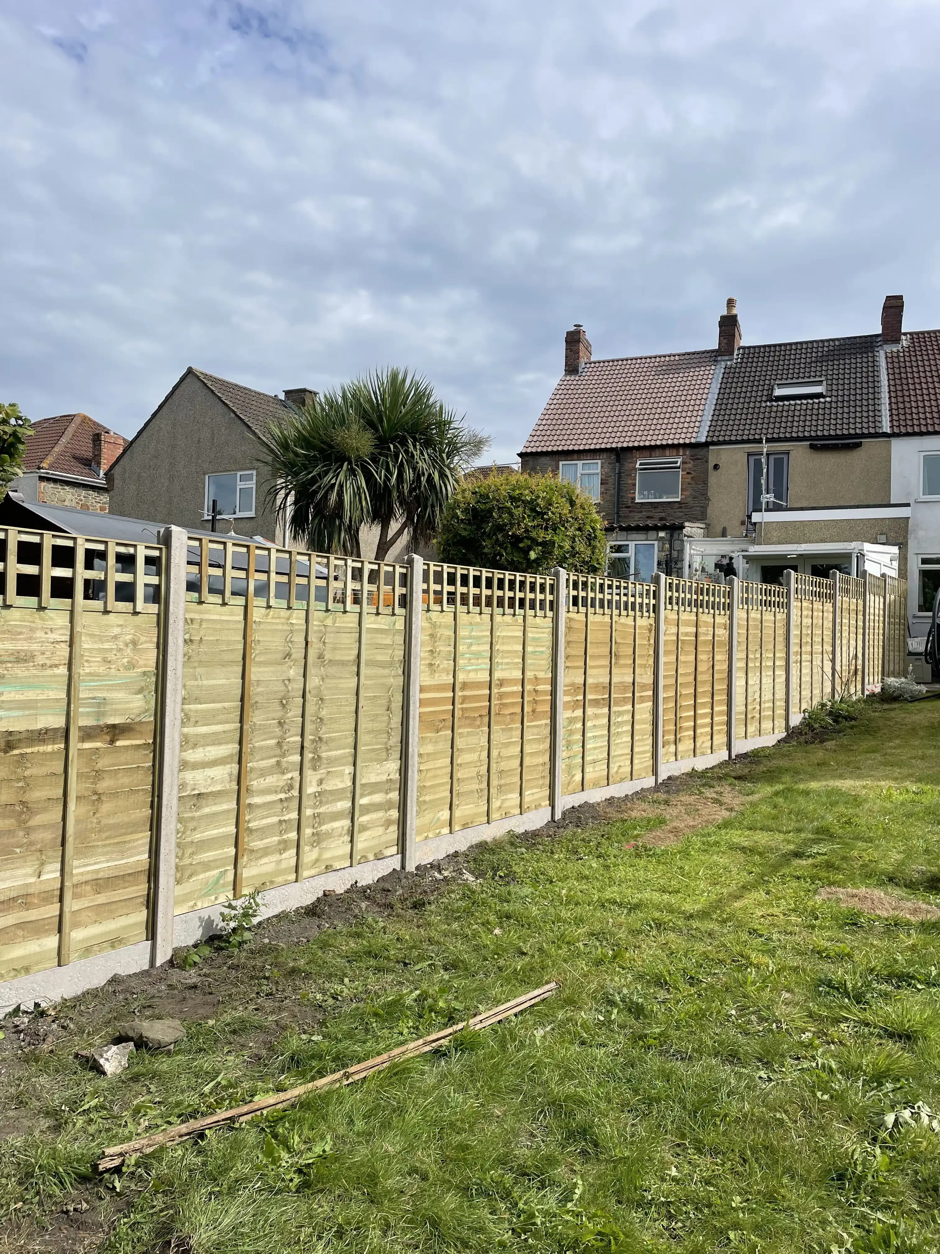 Trellis top closeboard fence along a garden lawn
