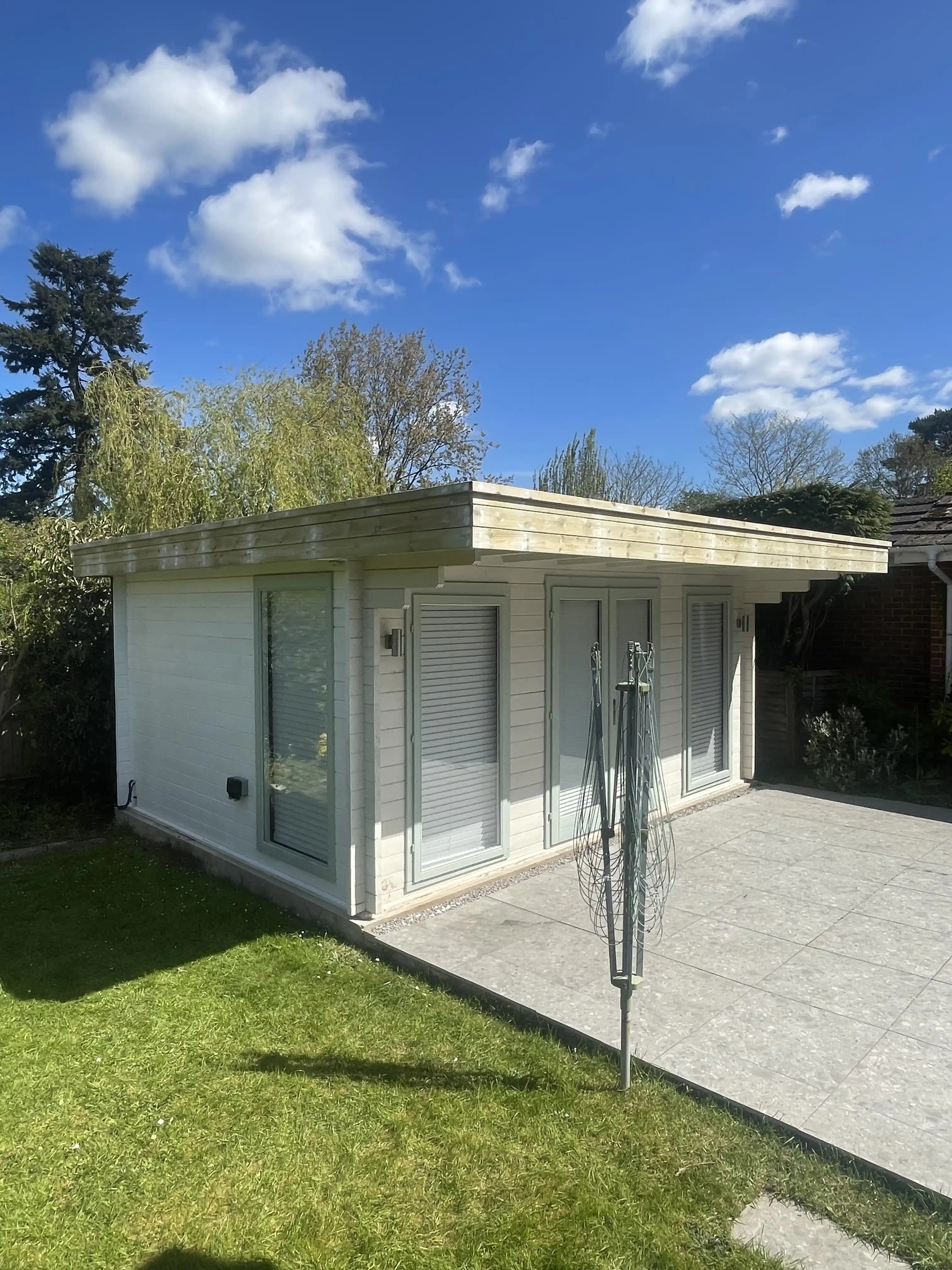 White garden room with glass veranda on a sunny lawn